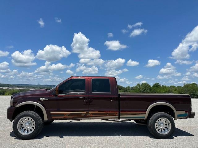 Auto body work before and after - after image. Maroon truck with deep scraping and dents repaired, now with new paint and beautiful custom detailing.